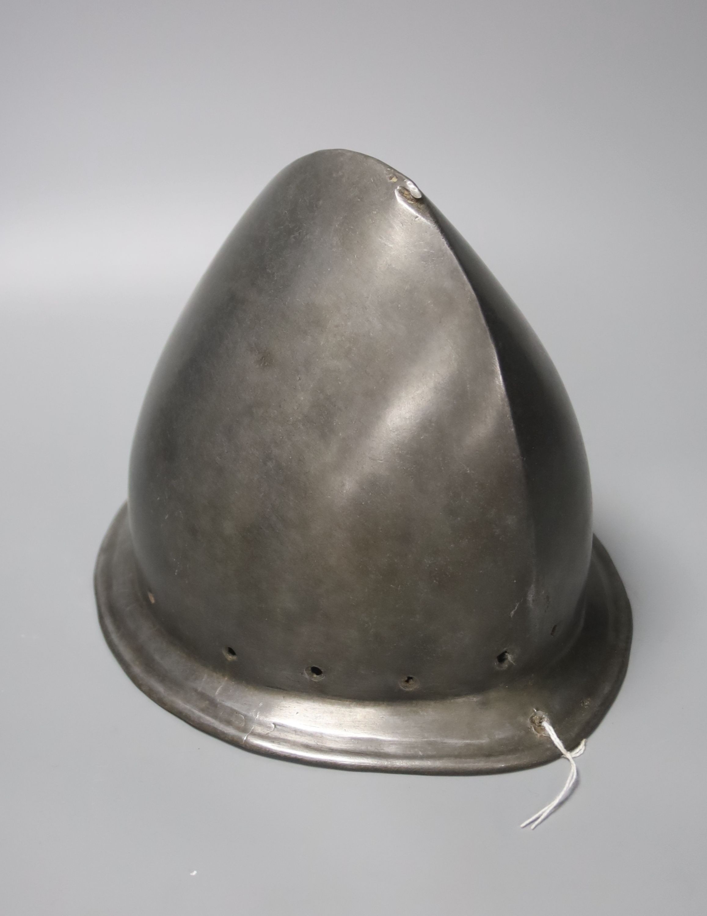 A good Italian Infantry Helmet Cabasset c.1580, polished steel raised from a single plate, medial ridge with pear stalk finial, borders pierced for rosettes, flared brim with turned over edge. Height 20cms.